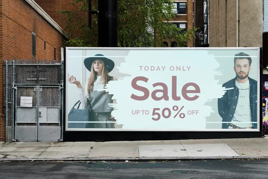 Outdoor digital numa calçada exibindo um anúncio de liquidação com duas modelos e a frase "Today only — Sale up to 50% off"