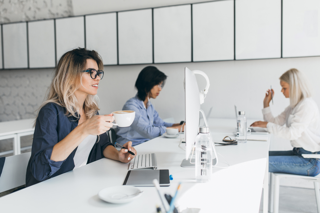comunicação corporativa: mulheres trabalhando em um escritório, com seus computadores